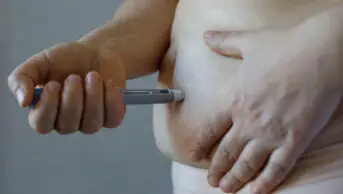 A person injects a weight-loss pen into their stomach