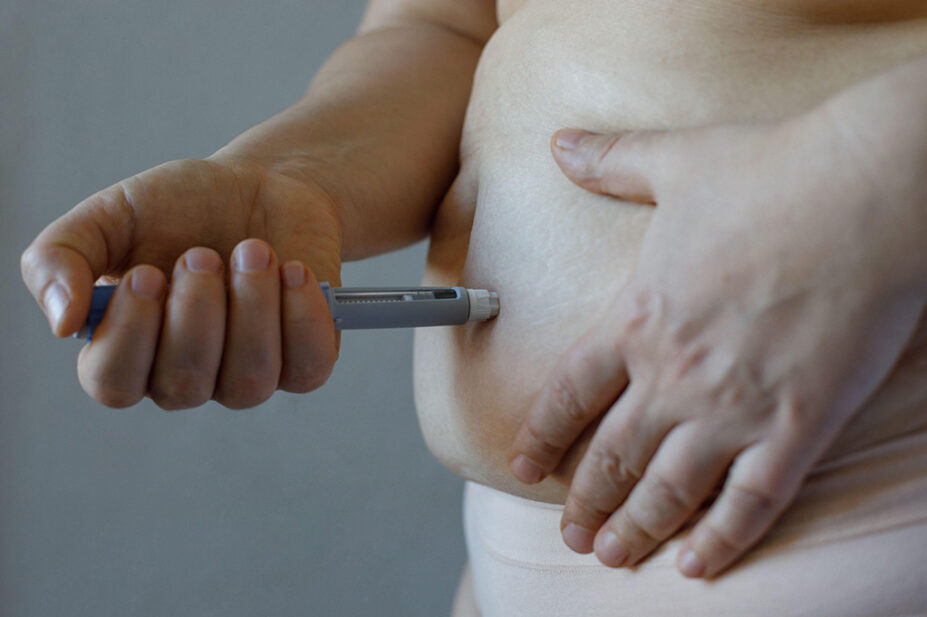 A person injects a weight-loss pen into their stomach
