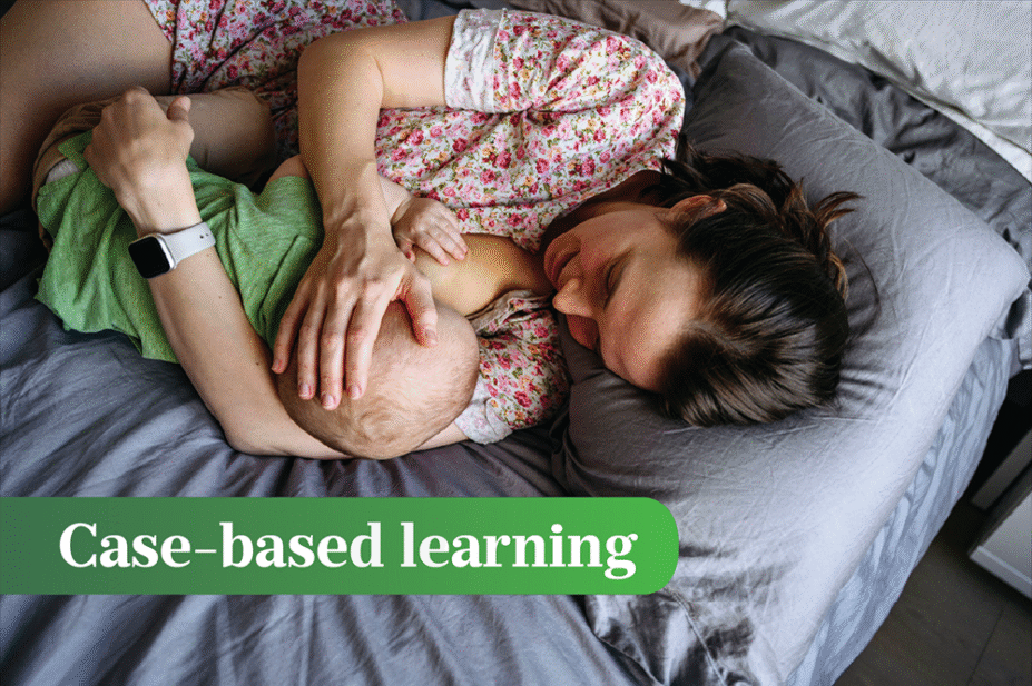 Breastfeeding woman and baby lie on a blue/grey bed