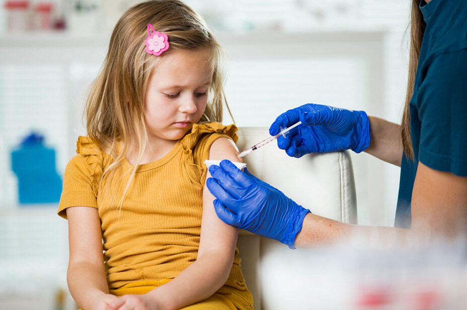 A young girl receives a vaccination from a healthcare professional