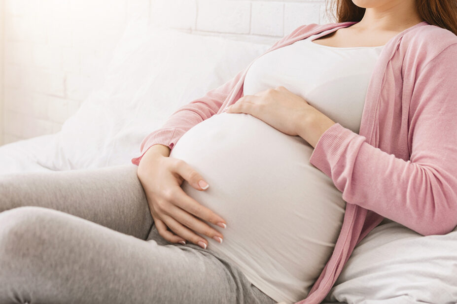 A pregnant woman holds her stomach
