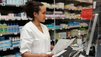 A pharmacist checks medication on a computer