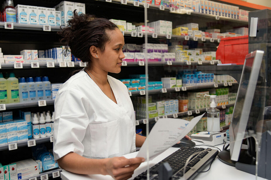 A pharmacist checks medication on a computer