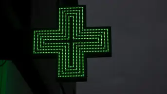 The sign outside of a community pharmacy at night