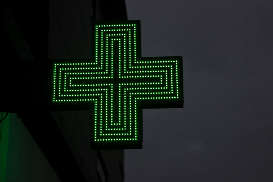 The sign outside of a community pharmacy at night
