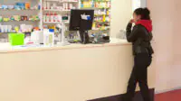 Teenager standing at a pharmacy counter