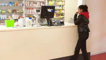 Teenager standing at a pharmacy counter