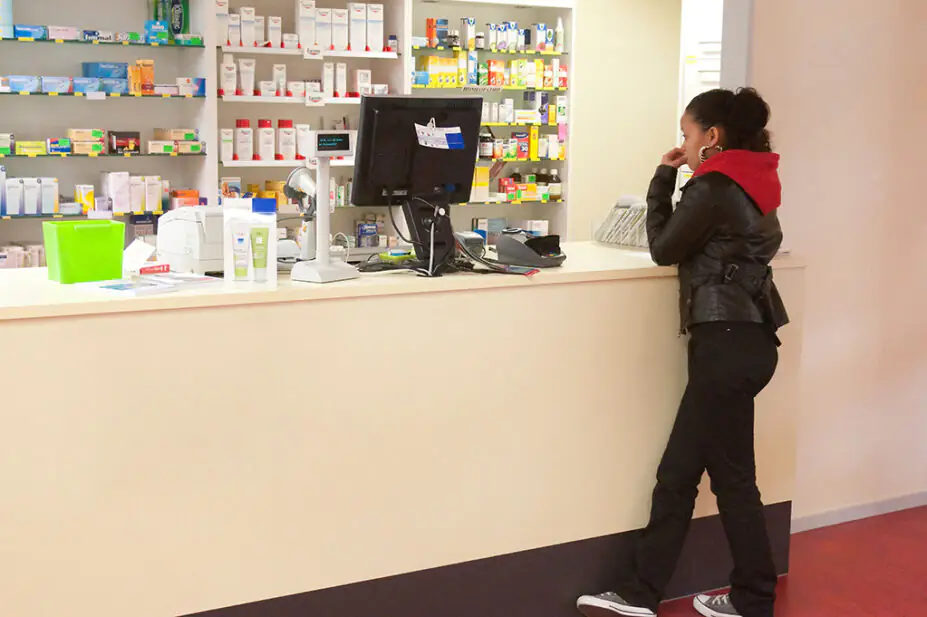 Teenager standing at a pharmacy counter
