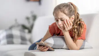 A teenage girl uses a smartphone
