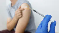 A young person receives a COVID-19 vaccination