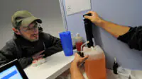 A healthcare professional prepares methadone for a patient