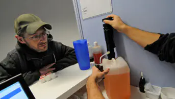 A healthcare professional prepares methadone for a patient