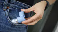 A person holds a salbutamol inhaler