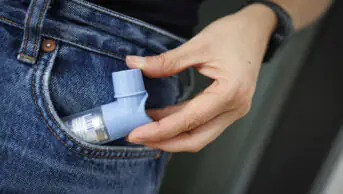 A person holds a salbutamol inhaler