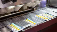 A machine packages tablets into blister packs