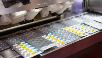 A machine packages tablets into blister packs