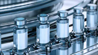 Conveyor belt with glass vials at pharmaceutical factory