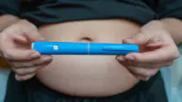 A woman holds a weight-loss pen