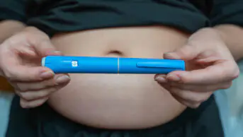 A woman holds a weight-loss pen