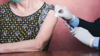 Older woman receiving vaccinations in upper arm