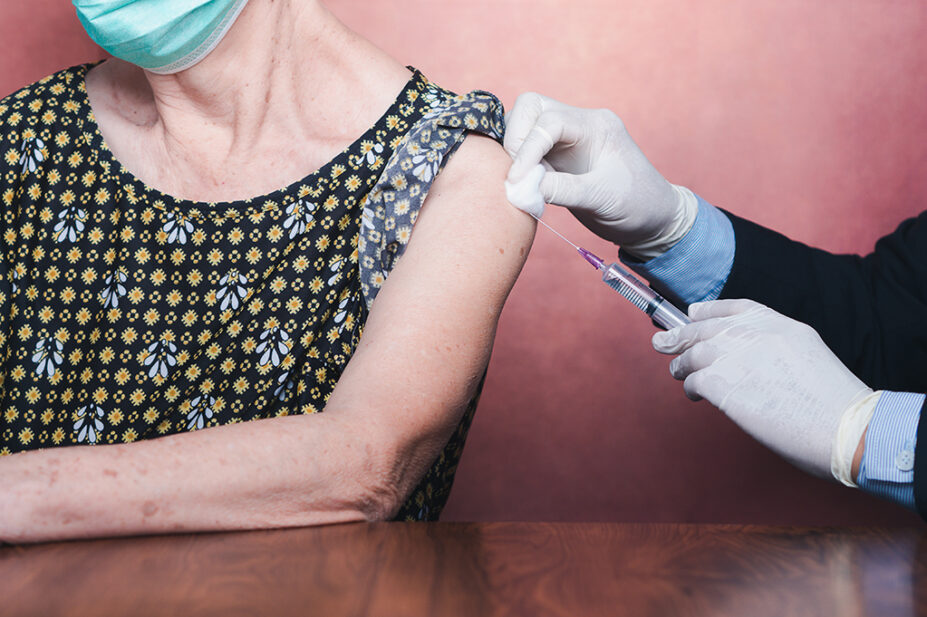 Older woman receiving vaccinations in upper arm
