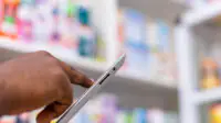 Pharmacist using tablet in a pharmacy setting