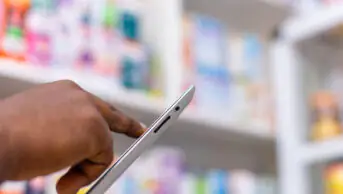 Pharmacist using tablet in a pharmacy setting