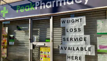 Notice of weight-loss service in window of local community pharmacy
