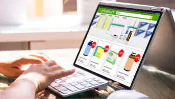 A person uses an online pharmacy on their laptop
