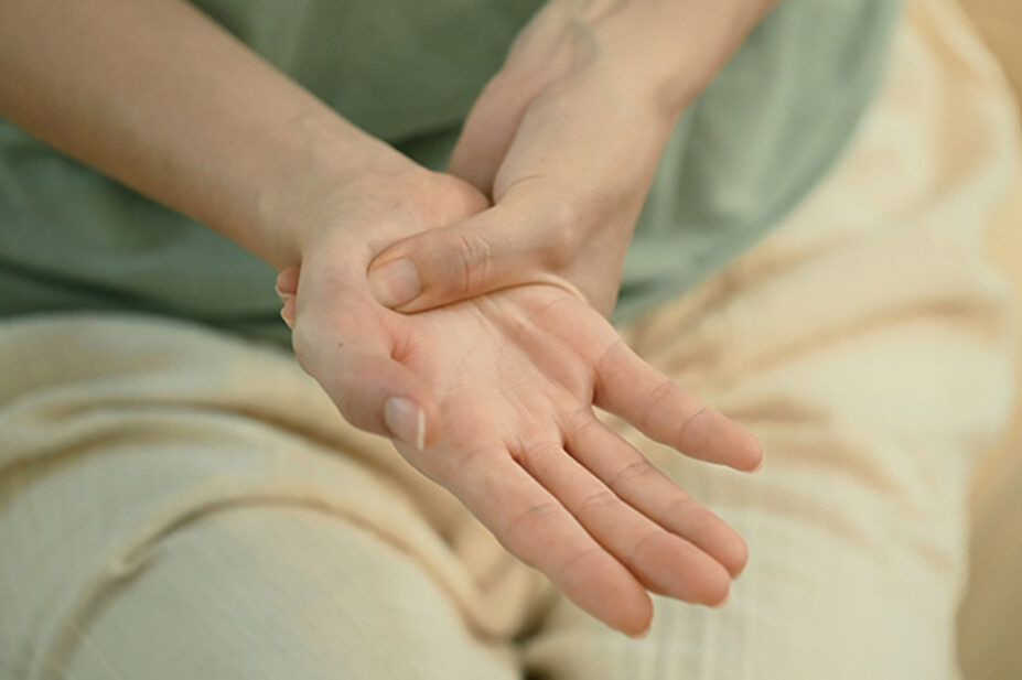 woman holding hands, suggestive of pain