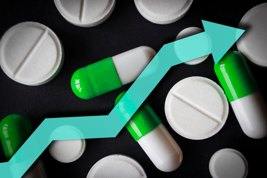 Black background with white pills and green and white tablets and a blue arrow pointing upwards