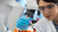 A scientist examines a patient's blood during a clinical trial