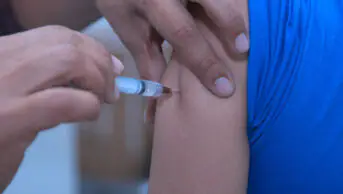 A healthcare professional gives a patient and injection in their arm