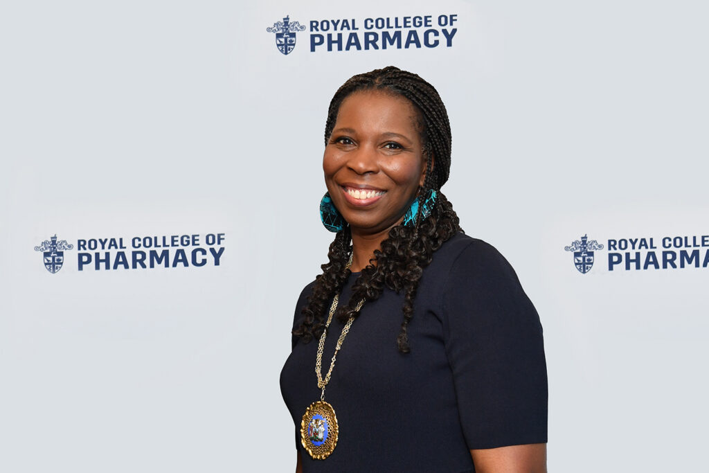 Tase stands in front of a white banner with RCPharm logos on it