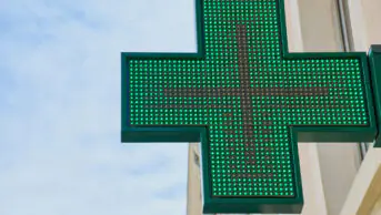 The neon sign outside of a community pharmacy