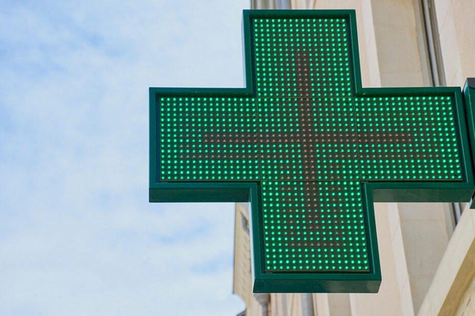 The neon sign outside of a community pharmacy