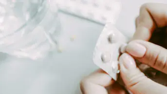 Close up of someone opening blister packet of pills