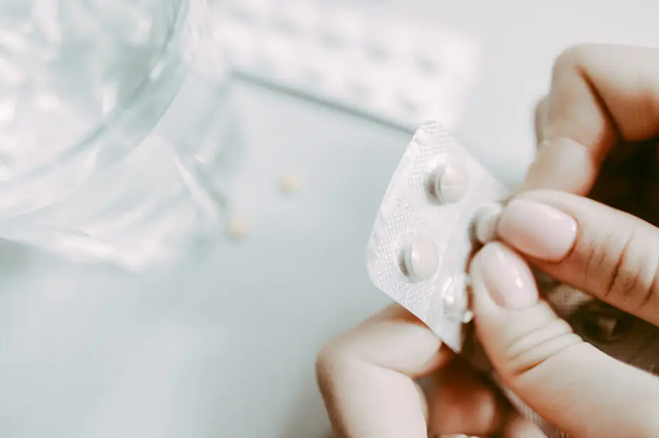 Close up of someone opening blister packet of pills