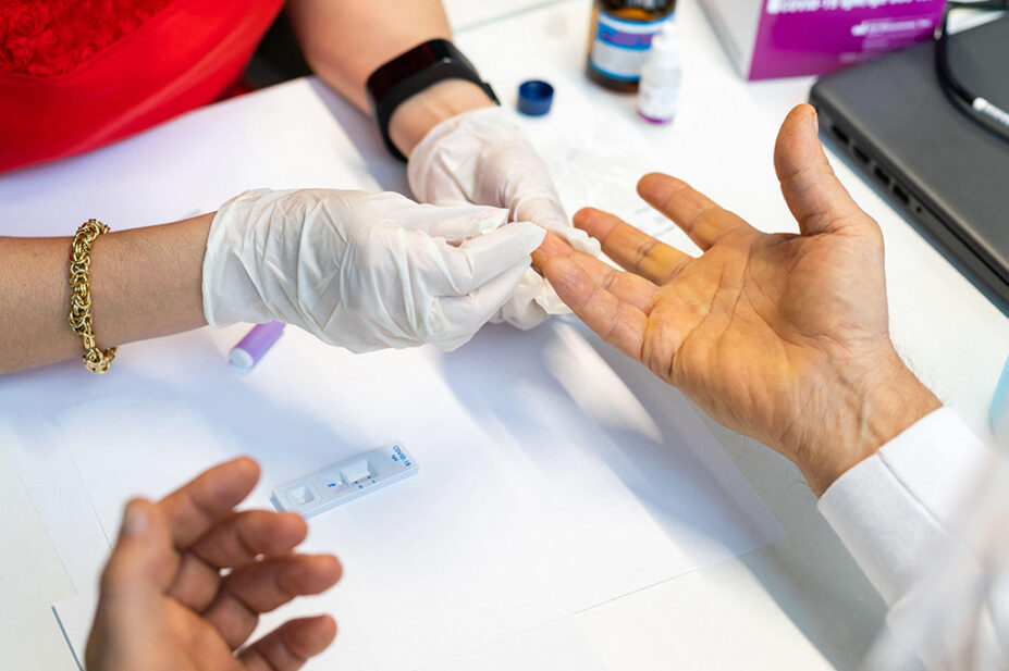 Pharmacist taking a patient's sample using finger prick test