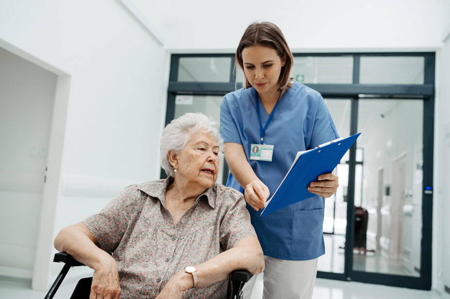 Nurse talks to older woman as she is discharged from hospital