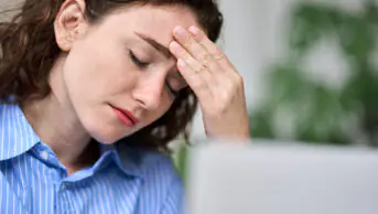 A woman suffers from a migraine