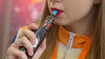 A woman smokes a vape