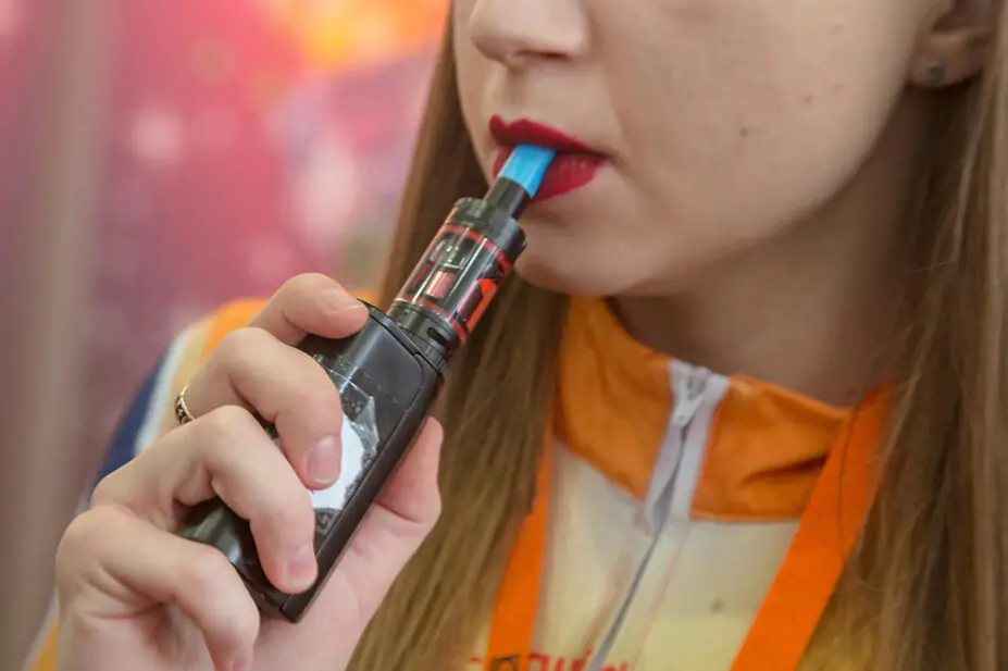 A woman smokes a vape