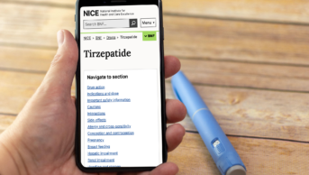 Person holding phone open to the BNF NICE page for Tirzepatide. A semaglutide injector pen rests on the table behind.