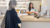A community pharmacist scans medication at the checkout counter