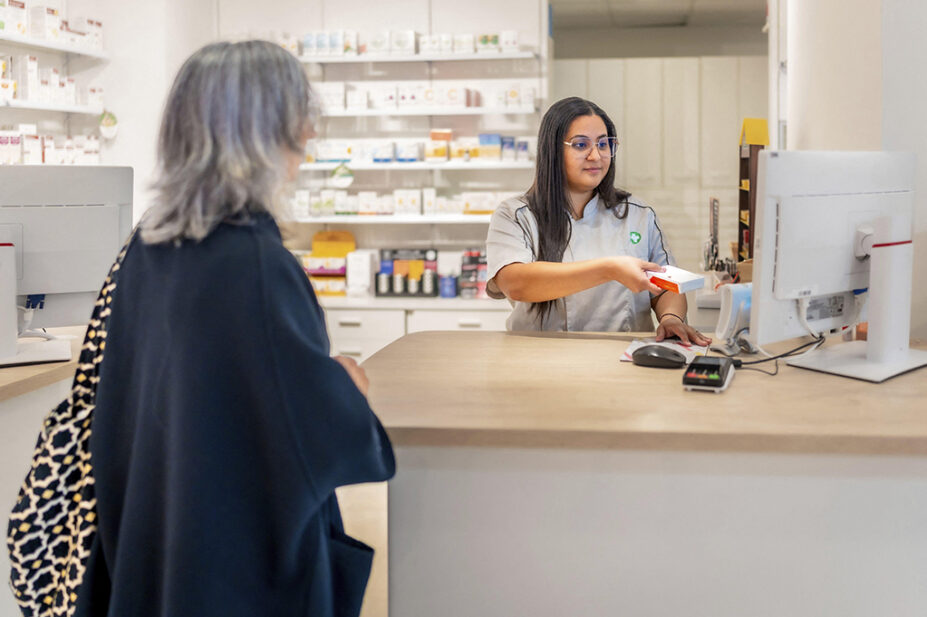 A community pharmacist scans medication at the checkout counter