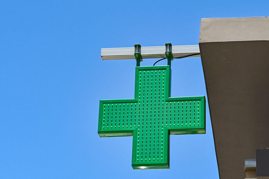 The green cross sign outside of a community pharmacy