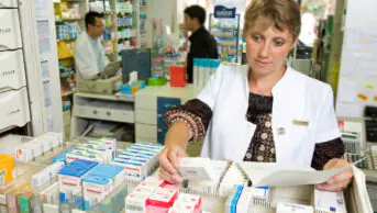 A community pharmacist stocks medication