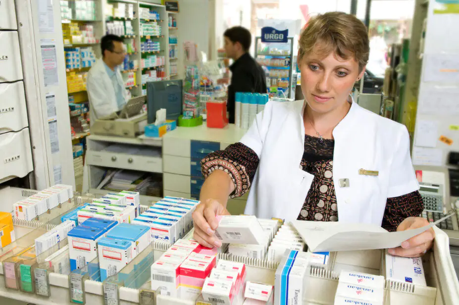A community pharmacist stocks medication