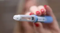 A woman holds an weight-loss injection pen